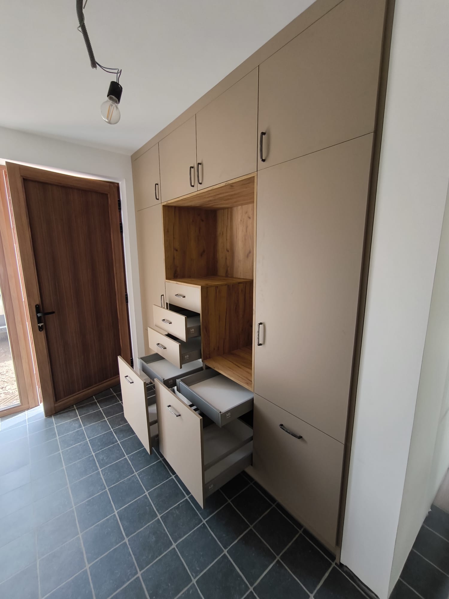 Maatkast op maat tot aan het plafond met lades, open houten nis en zwarte handgrepen